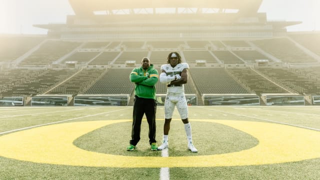 Running back Jay Harris poses with Oregon coach Carlos Locklyn inside Autzen Stadium.